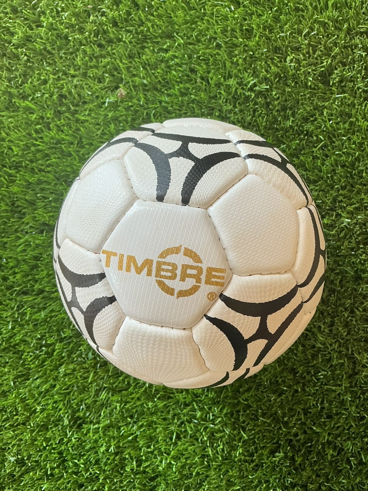 Bola Timbre branca e preta com logo dourado e gomos texturizados
